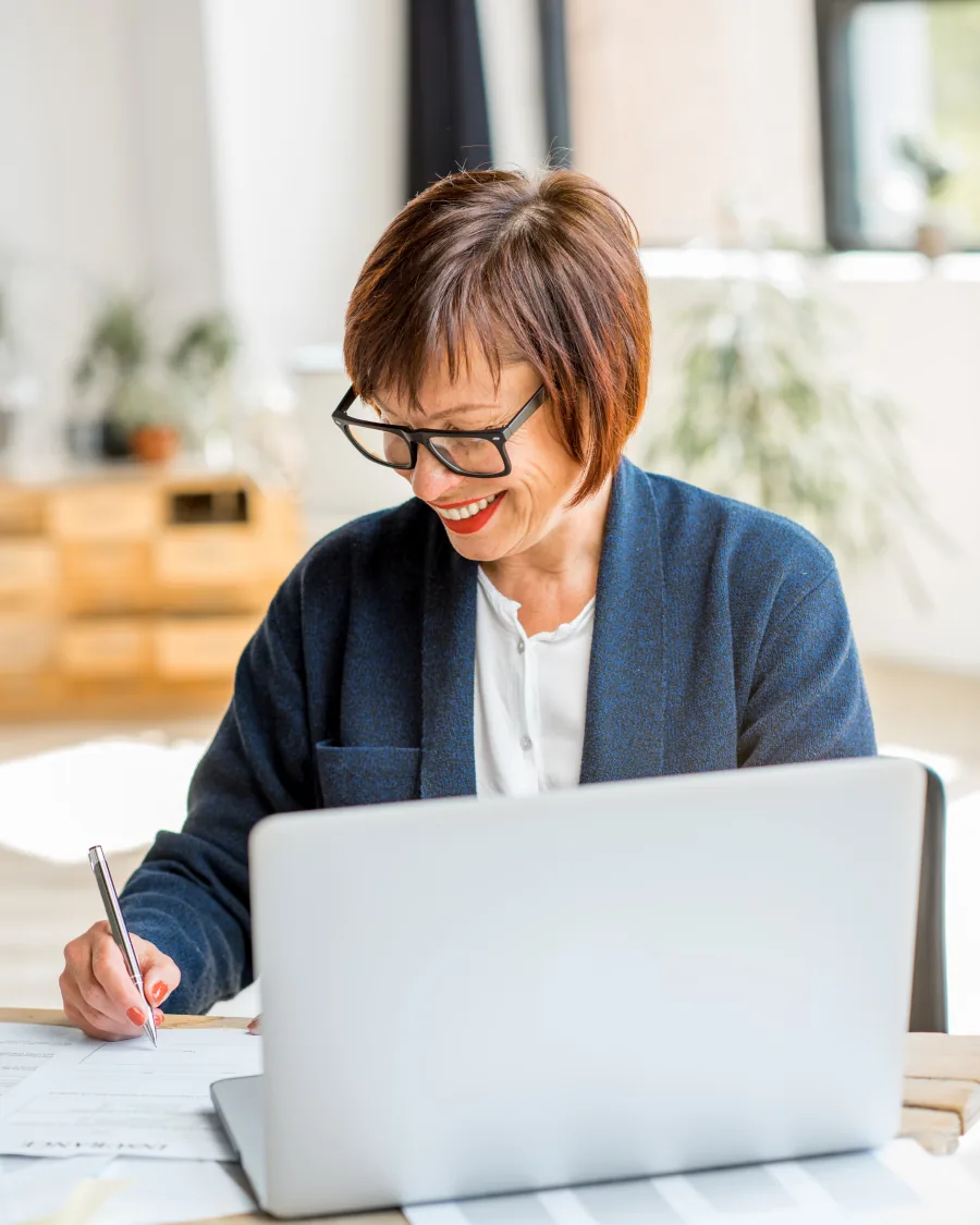 Professionista che lavora su documenti e computer in un ufficio luminoso